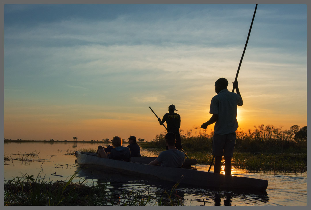 Mokorofahrt bei Sonnenuntergang - Das Fortbewegungsmittel im Okavango-Delta ist das Mokoro. Dieses traditionelle Einbaumboot besteht heute aus Fiberglas. Aber für die verworrenen Wege durch das Delta brauchen die Bootsführer, Poler genannt, weder GPS noch Karten.